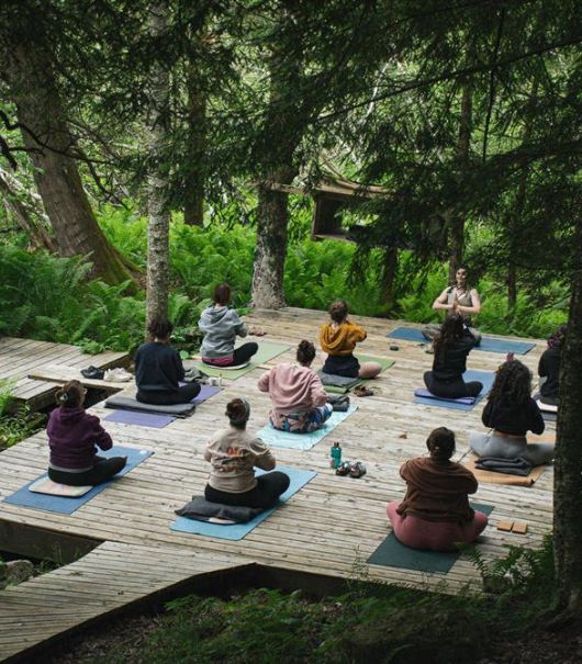 Atelier yoga en pleine forêt québécoise lors de la retraite trail bien-être Entre deux sentiers à l'Auberge La Salamandre